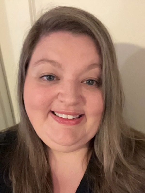 Female with long dark blonde hair parted on the side